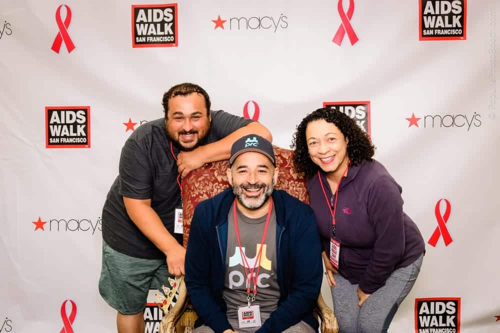 Participants posing in front of the AIDS Walk San Francisco backdrop featuring the Macy's logo, celebrating the event's spirit at the fundraiser.
