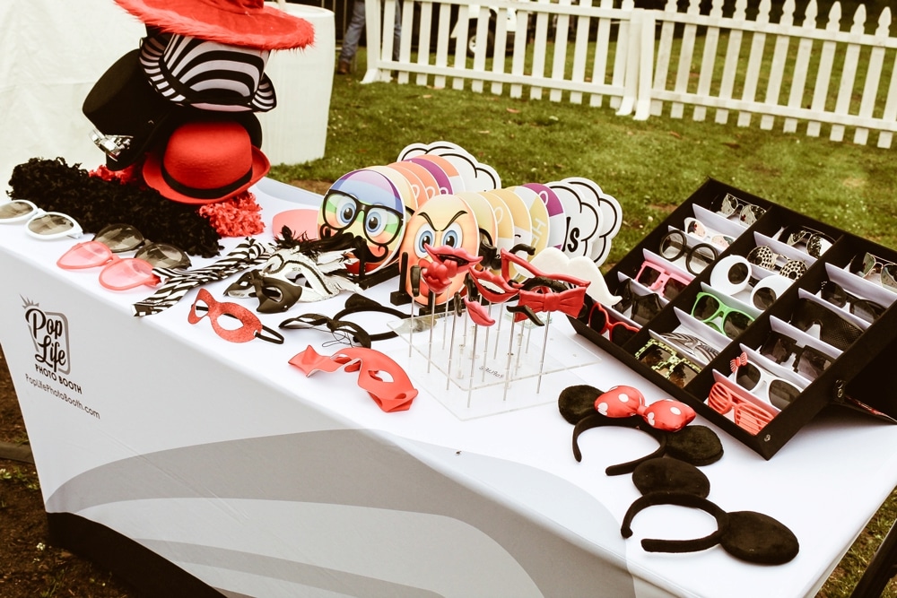 Table displaying fun photo booth props including hats, glasses, and masks for participants at the San Francisco AIDS Walk fundraising event by Pop Life Photo Booth.
