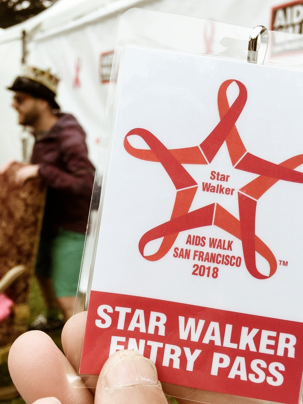 Star Walker entry pass for the 2018 San Francisco AIDS Walk, featuring red ribbons and a participant in the background, showcasing the event's spirit and community involvement.