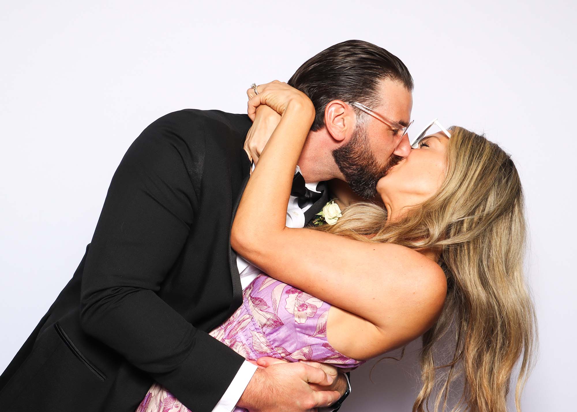 Couple sharing a romantic kiss in a photo booth, showcasing the popular "Big Kiss" pose for memorable photo sessions.