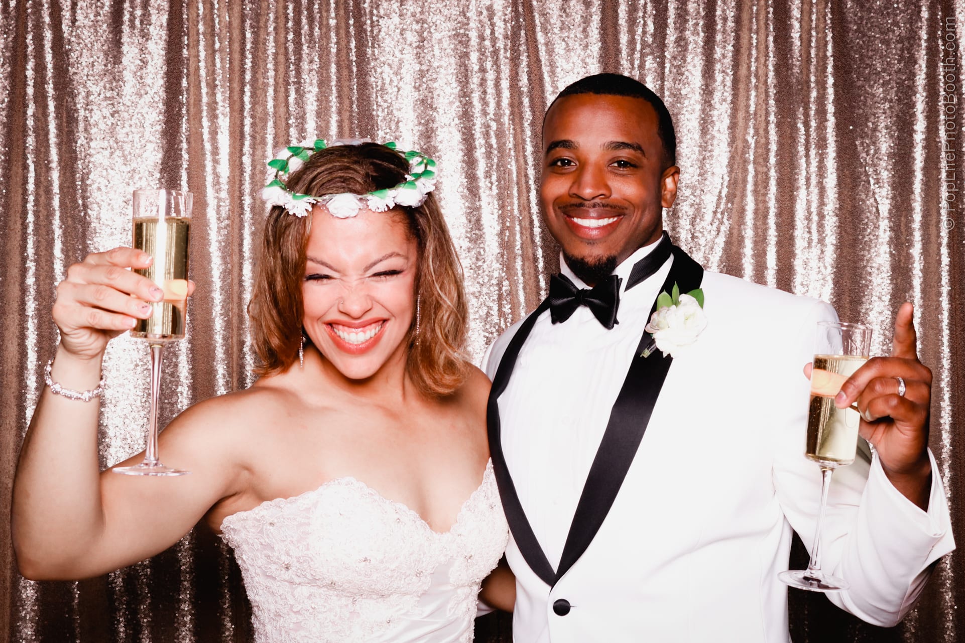 Bride and groom celebrating at wedding reception, holding champagne flutes, joyful expressions, with sparkling backdrop, highlighting the festive atmosphere of their special day.