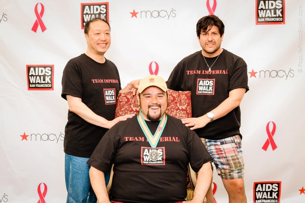 Three participants at the San Francisco AIDS Walk posing for a photo, wearing matching black shirts with "TEAM IMPERIAL" and "AIDS WALK SAN FRANCISCO" logos, celebrating their participation and achievements.