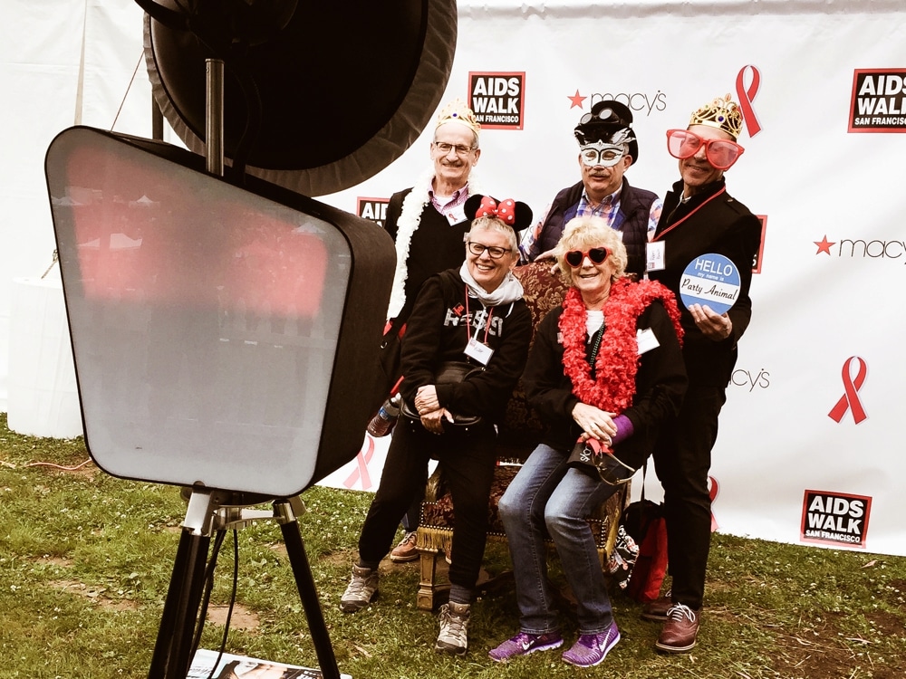 Group of participants posing in costumes with props at the San Francisco AIDS Walk photo booth, showcasing team spirit and fun atmosphere.