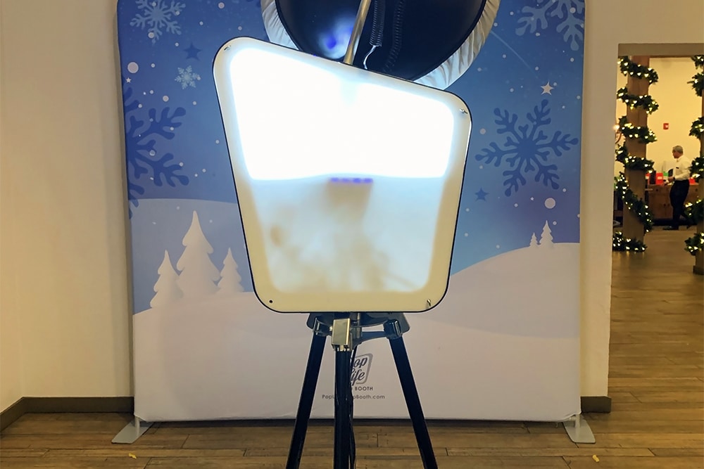 Photo booth setup with winter-themed backdrop featuring snowflakes, promoting Pop Life Photo Booth services for events at Wente Vineyards.