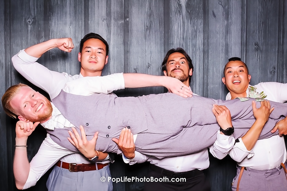 Groom being playfully lifted by groomsmen in a fun photo booth setting at The Ranch at Little Hills, San Ramon, capturing joyful moments from a wedding celebration.