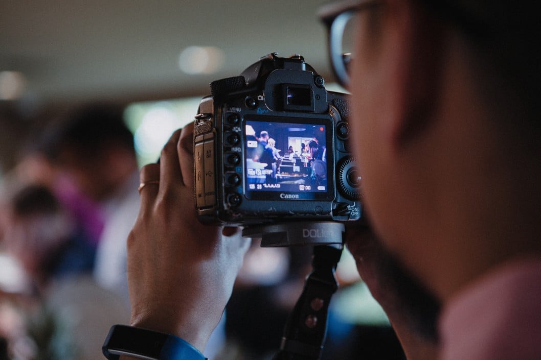 Photographer capturing moments at a corporate event with a digital camera, showcasing the lively atmosphere and guest interactions.