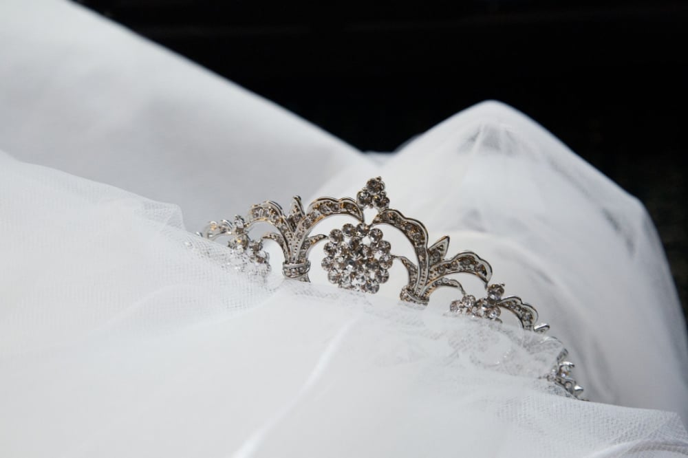 Bridal tiara resting on white tulle, ideal accessory for wedding hairstyles, enhancing elegance and style.
