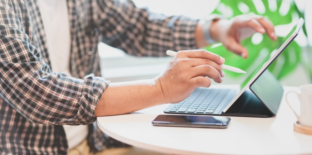 Young professional businessman strategizing on tablet, preparing for a germ-free event.
