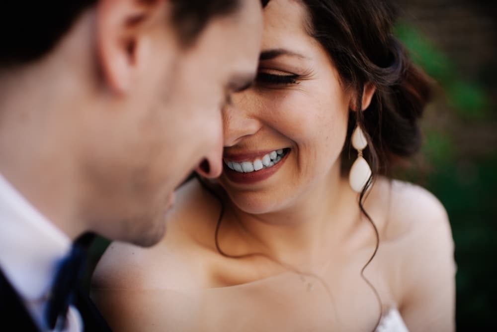 Happy couple sharing a joyful moment, smiling closely together, celebrating their love and connection during wedding planning.