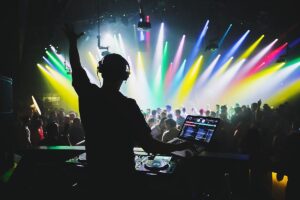 DJ performing at a vibrant party with colorful lights and a lively crowd, enhancing the celebration atmosphere for events.