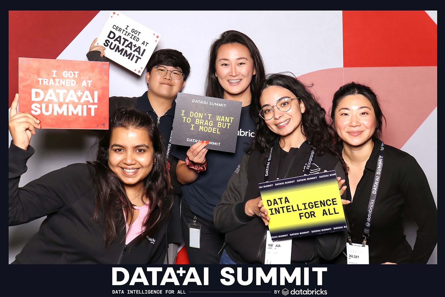 Group of five smiling attendees at the Data + AI Summit holding custom props with phrases like "I got trained at DATA+AI SUMMIT" and "DATA INTELLIGENCE FOR ALL," showcasing engagement and fun at Pop Life Photo Booth's corporate event setup.