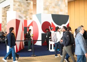 Corporate photo booth at Data + AI Summit featuring modern design with vibrant geometric patterns and attendees engaging in networking.