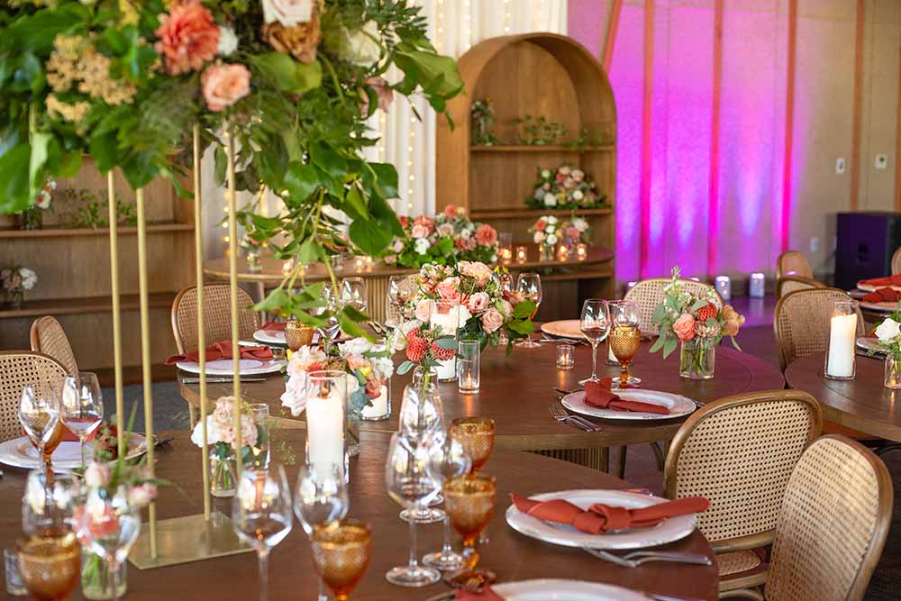 Elegant dining setup with floral centerpieces, candles, and decorative tableware in a warm, inviting event space at Treehouse Silicon Valley, ideal for weddings and gatherings.