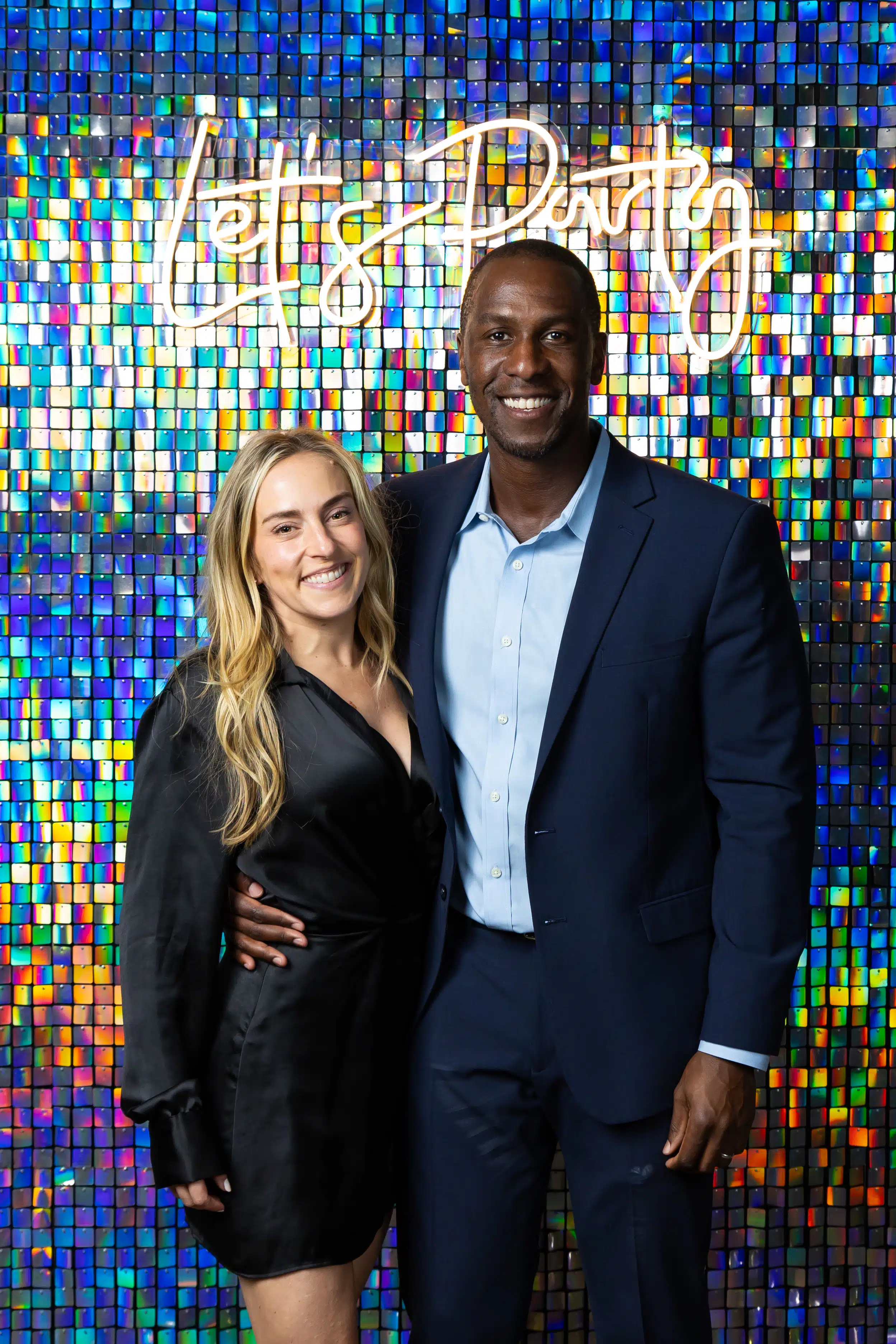 Couple posing for portrait photography at event, custom branded backdrop, instant digital delivery.