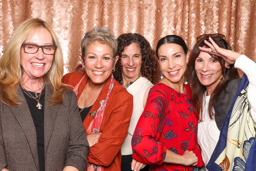 Glam Photo Booth experience with smiling guests and branded sequin backdrop.