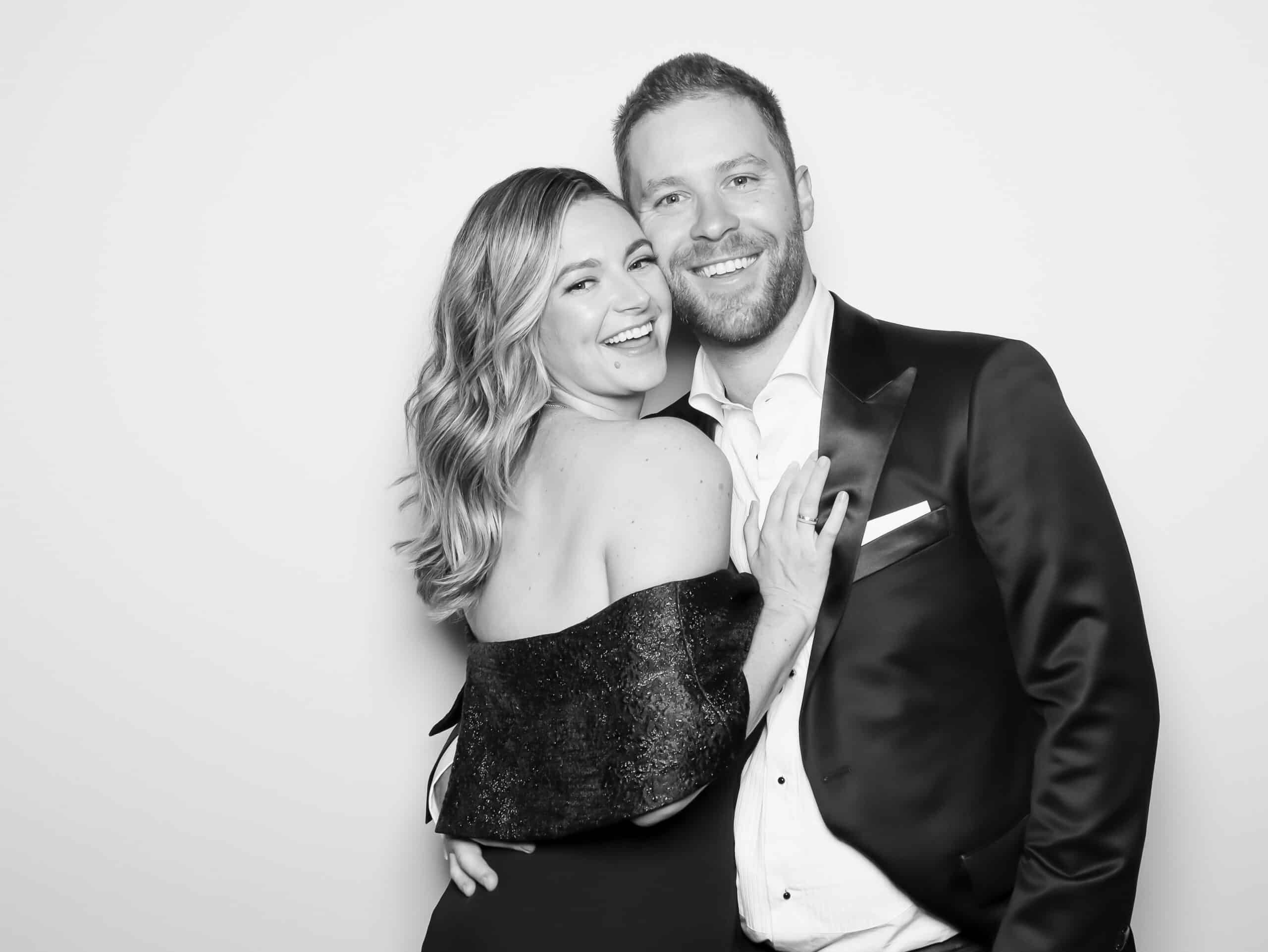 Couple posing together in a glamorous black-and-white photo, showcasing joyful expressions, reflecting luxury wedding photography services offered by Pop Life Photo.