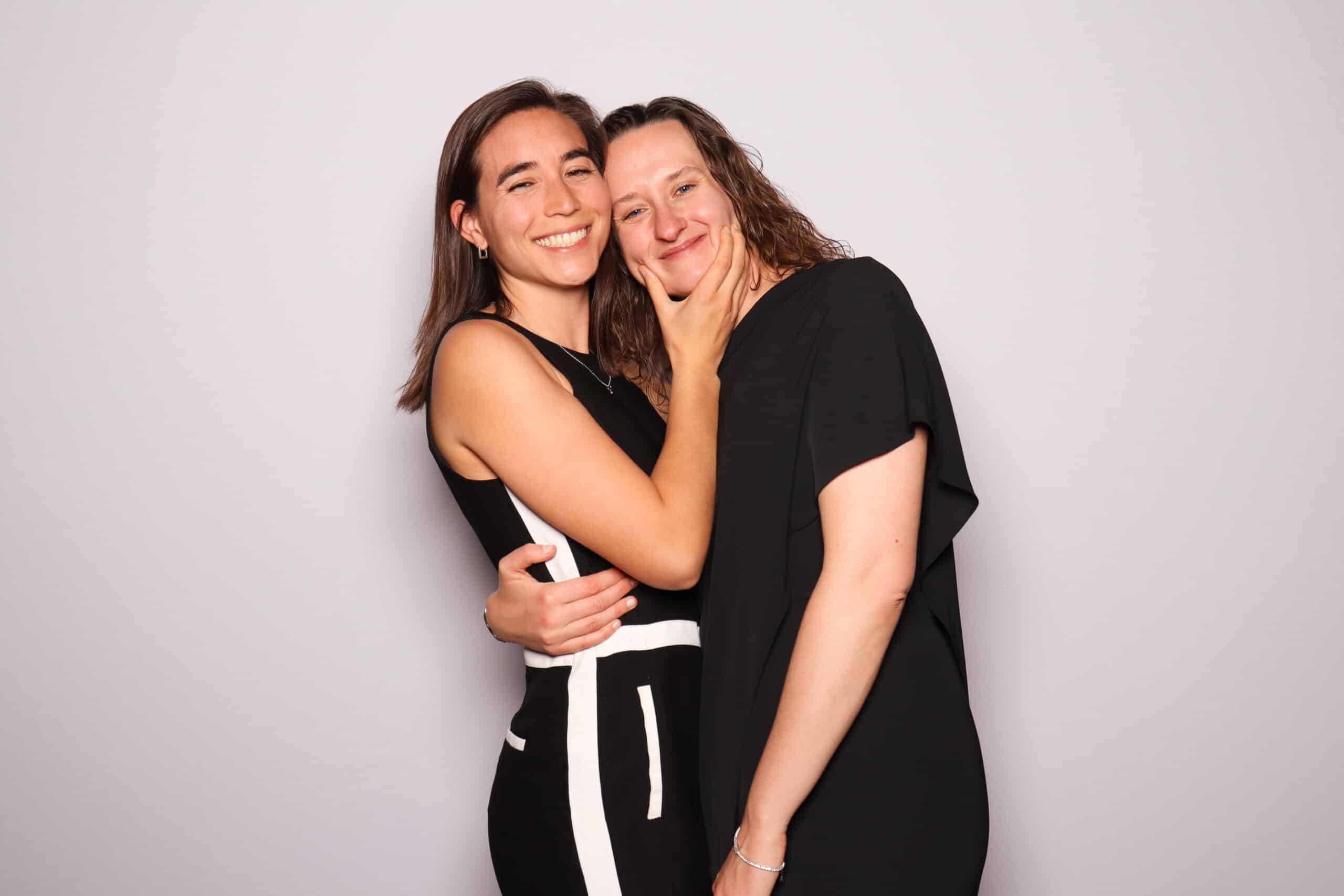 Two guests smiling and embracing in a Pop Life Photo glam booth experience.