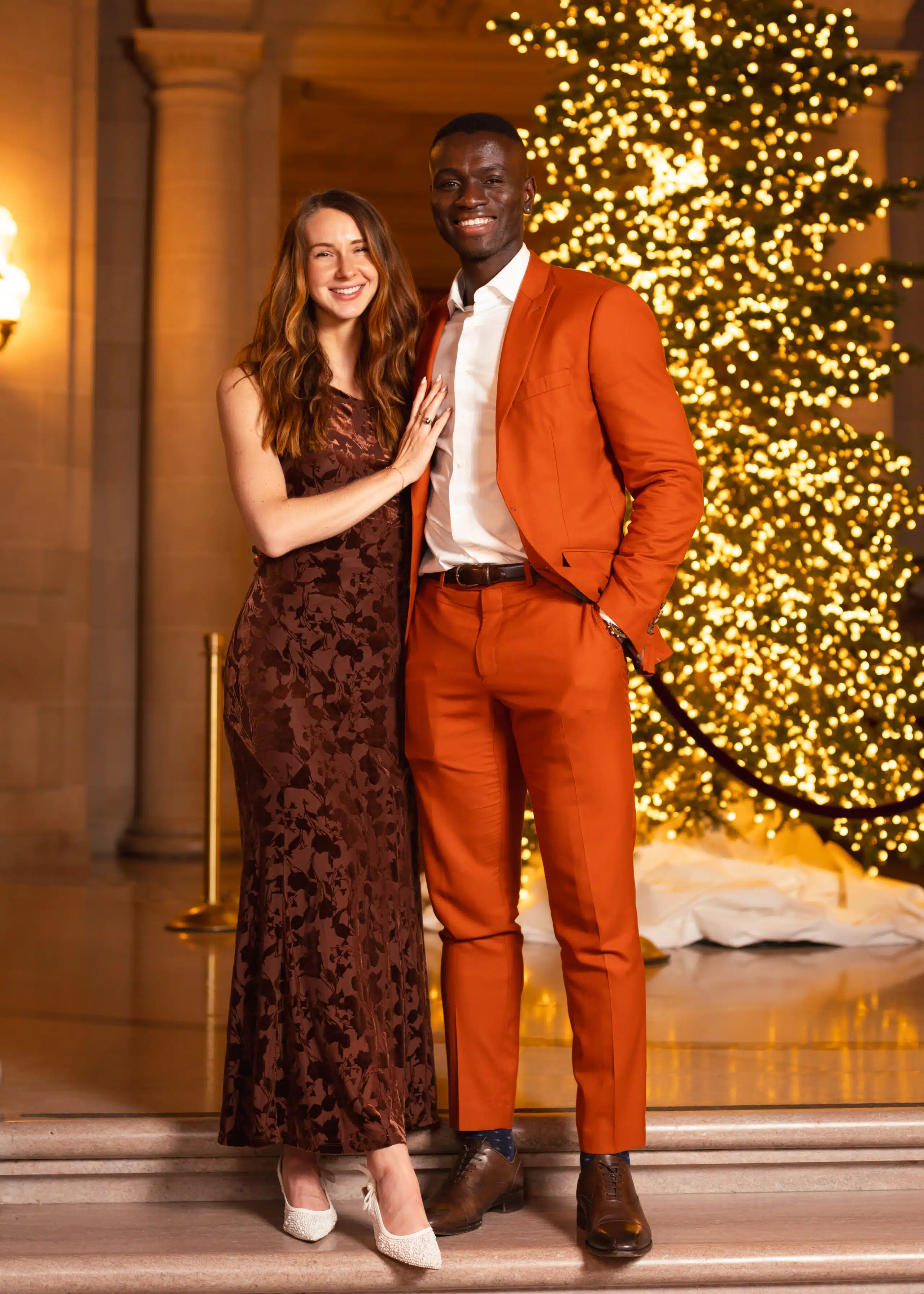 Couple posing for portrait photography at McKinsey holiday celebration in San Francisco City Hall.