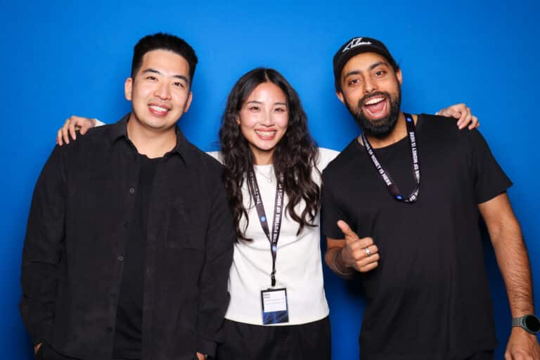 Group of smiling guests enjoying a branded photo booth experience at a corporate event.