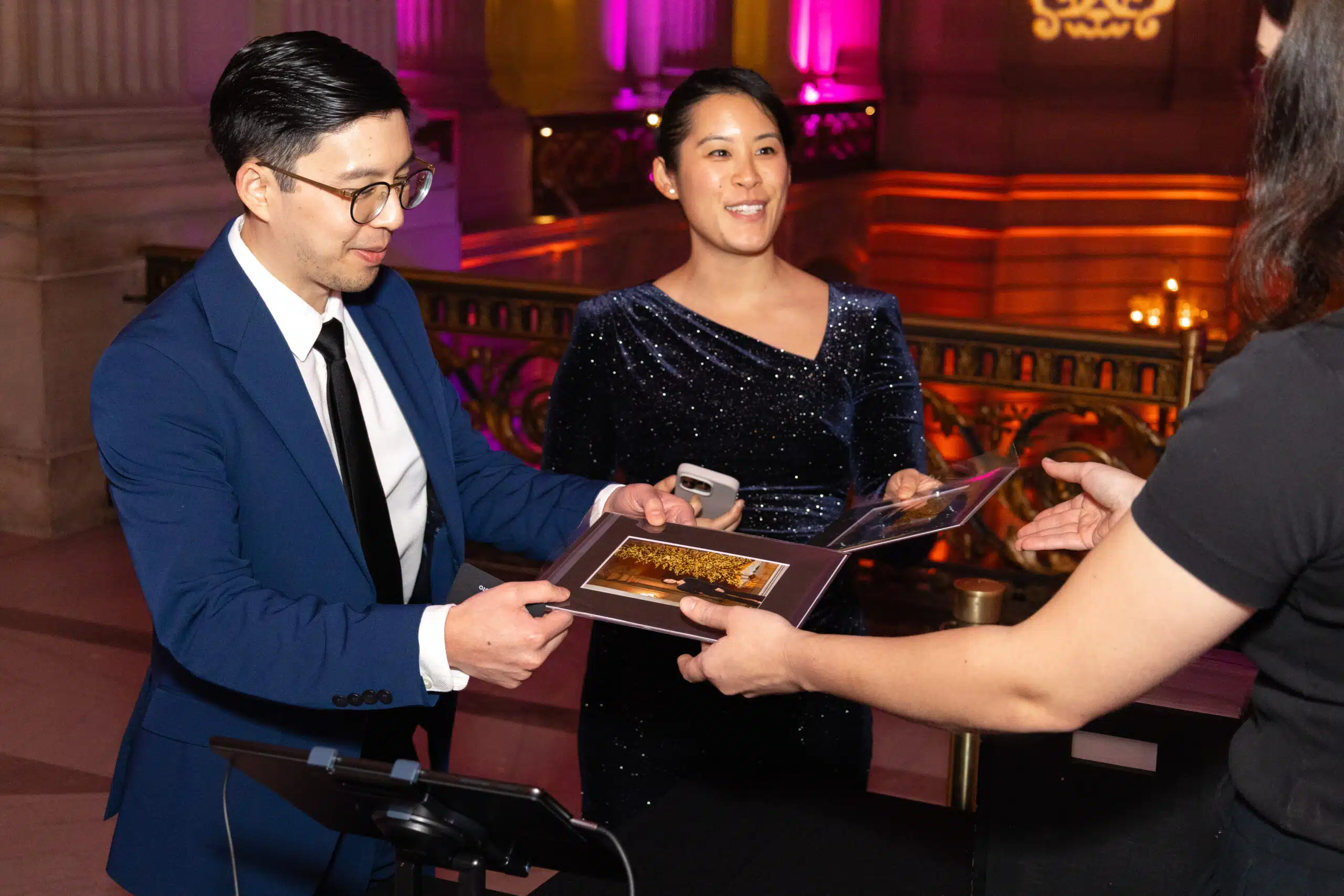 McKinsey holiday celebration guests receiving printed photo keepsakes and portraits at San Francisco City Hall.