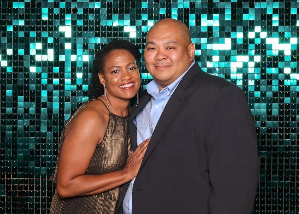Teal shimmer wall backdrop with metallic panels reflecting light, enhancing photo booth experience for modern luxury events.