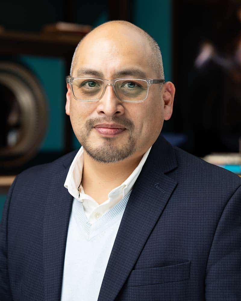 Professional headshot of a man wearing glasses and a blazer, showcasing confidence and approachability, ideal for corporate branding and event photography.