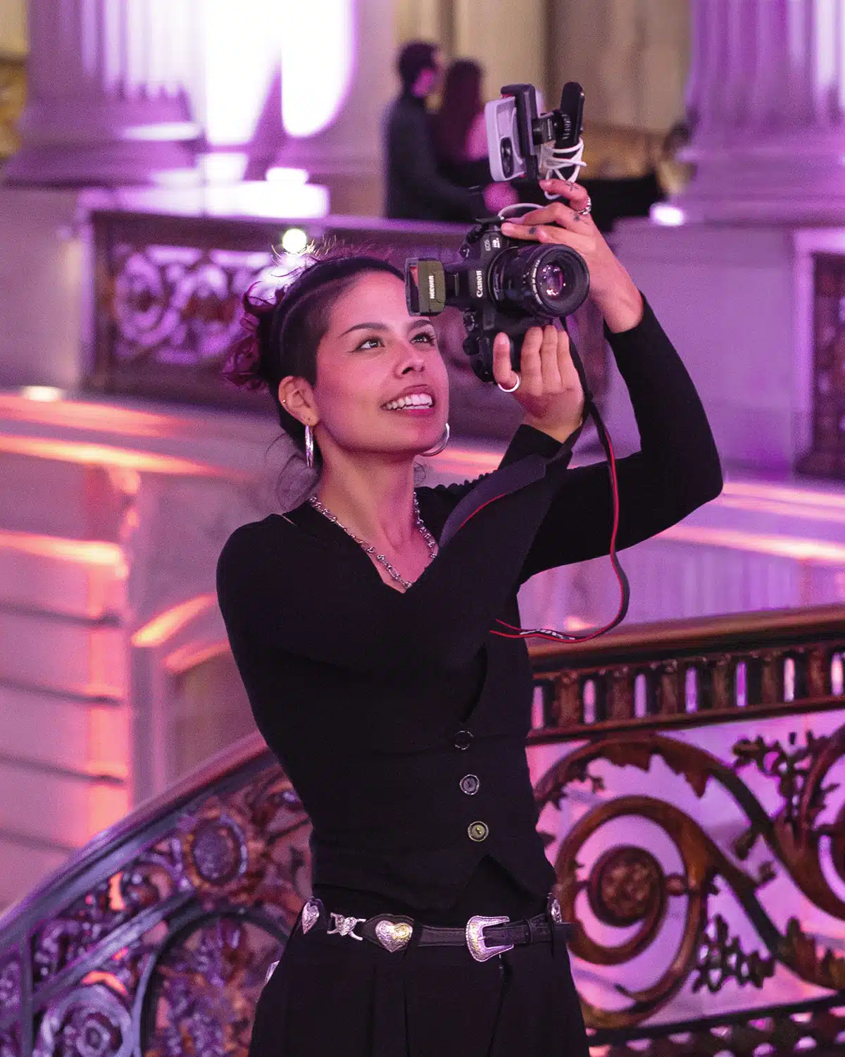 Professional photographer capturing moments at a luxury wedding event, featuring elegant decor and warm lighting.