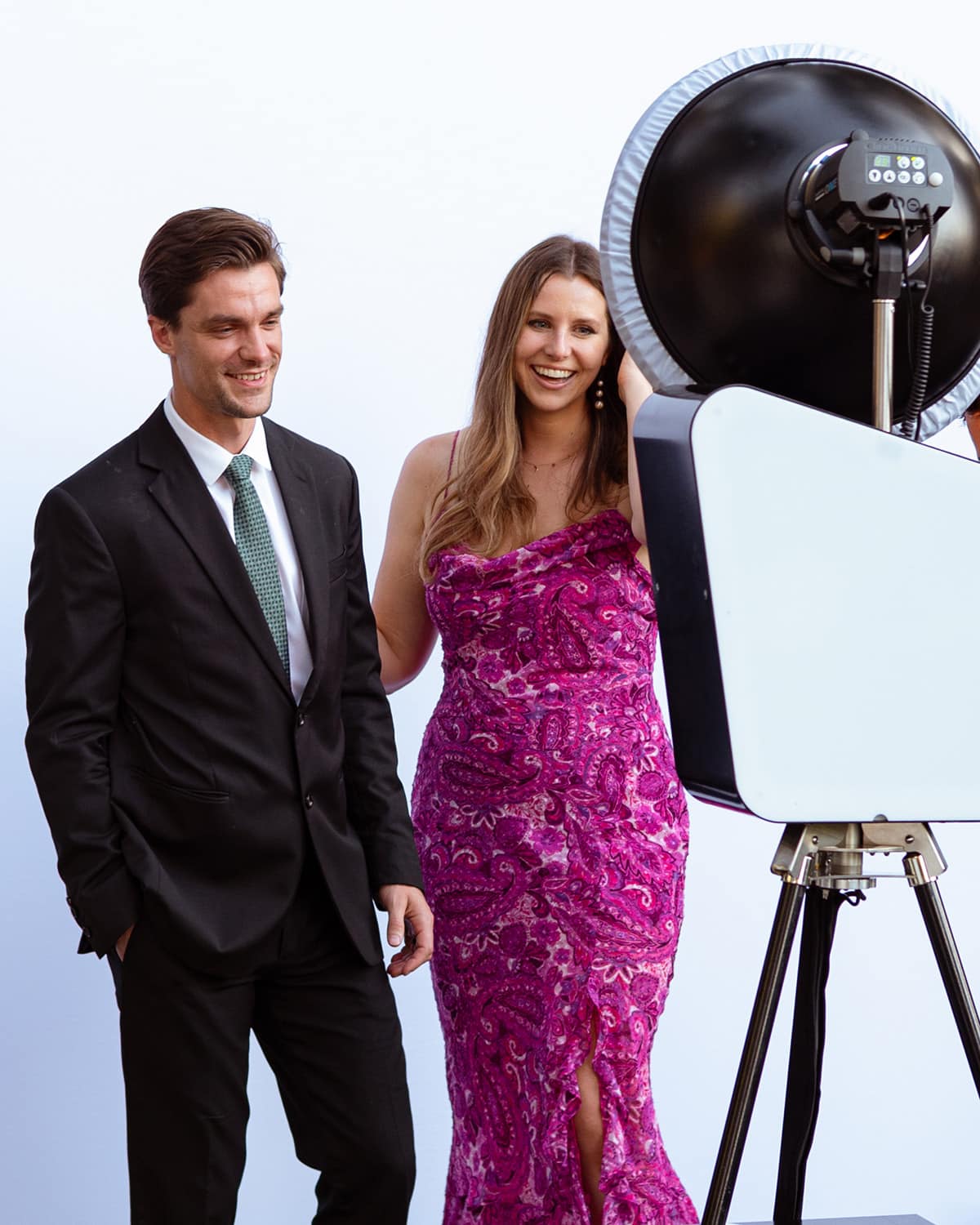 Couple enjoying a glamorous photo booth experience with professional lighting, capturing high-energy moments at an upscale event.