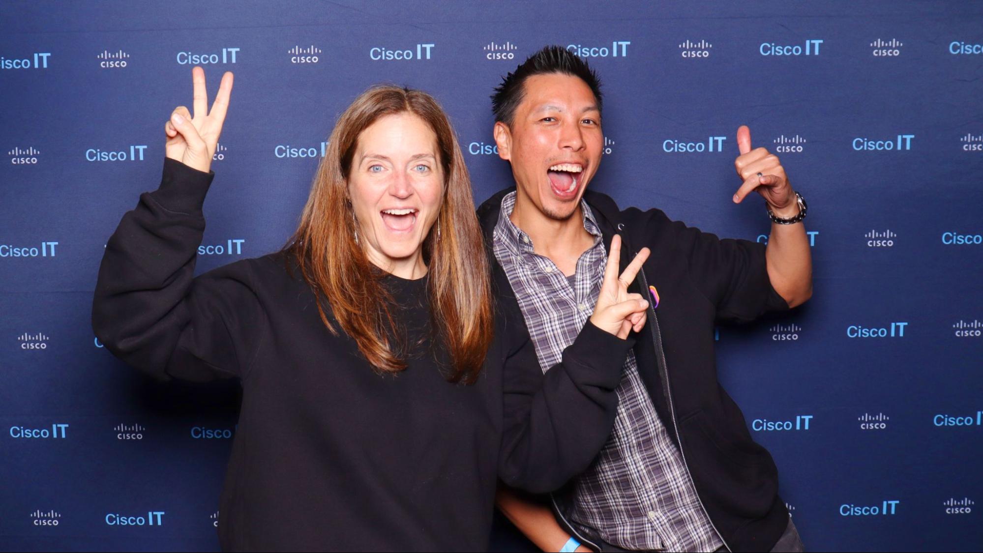 Happy guests posing with peace signs at a Cisco IT branded photo booth, showcasing a fun and engaging corporate event experience.