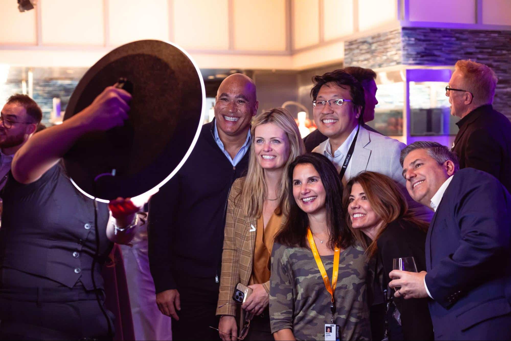 Group of guests posing for a photo at an event, enjoying the interactive AI Photo Booth experience with a ring light, capturing personalized moments and engaging with creative transformations.