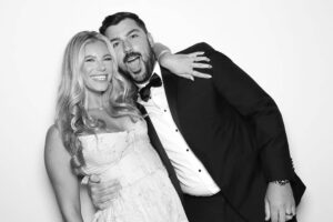 Couple posing playfully in a photo booth, radiating joy and intimacy, capturing a romantic moment together.