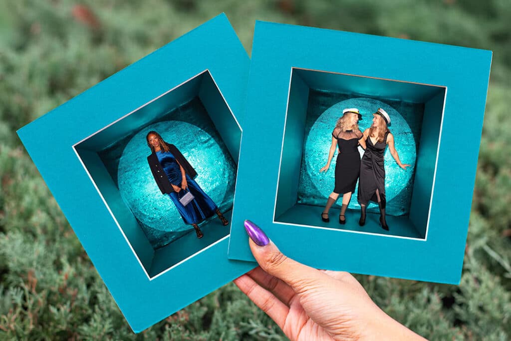 Luxury photo booth experience showcasing two framed images of guests in stylish outfits, featuring a vibrant teal backdrop, emphasizing high-end event aesthetics and personalized activations.