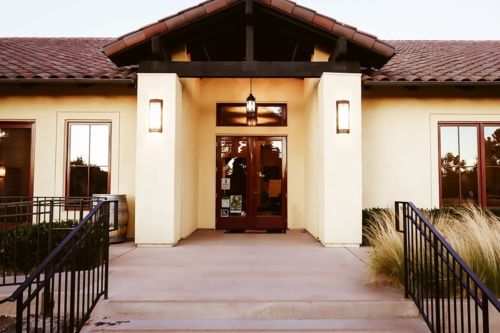 Livermore vineyard venue entrance with modern architecture, welcoming atmosphere, and surrounding greenery, ideal for weddings and corporate events.