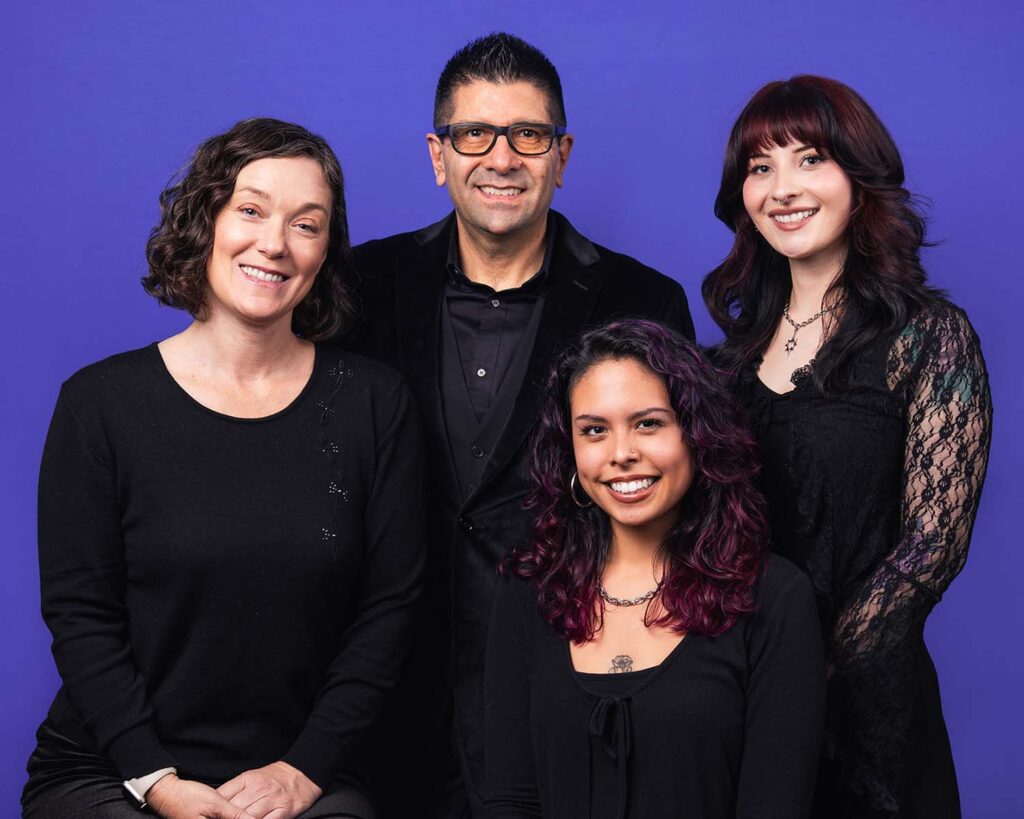 Team members of Pop Life Photo Booth posing against a purple background, showcasing their professional and engaging atmosphere in event photography.