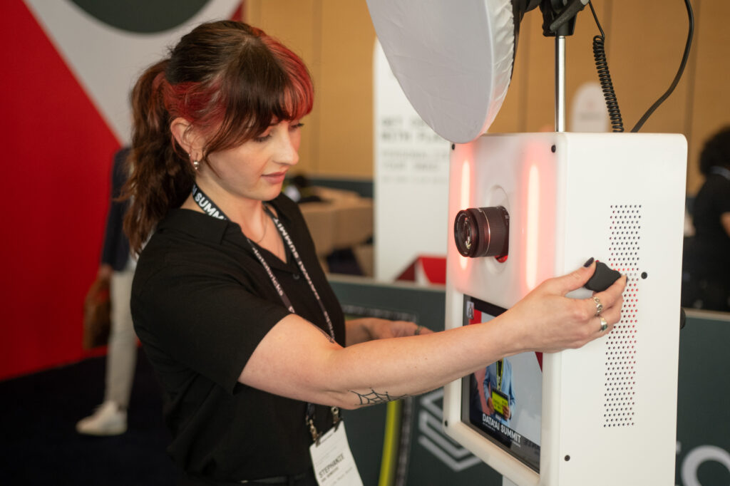 Corporate photo booth attendant assisting guest with branded photo experience