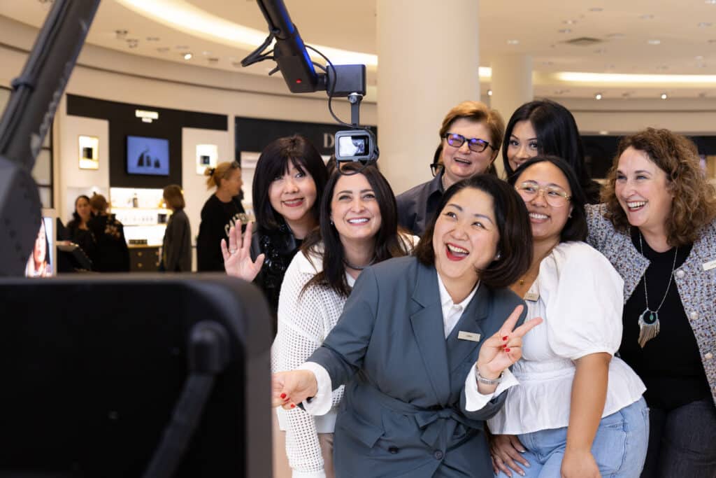 Group of women smiling white posing for a photo with a Glambot-X