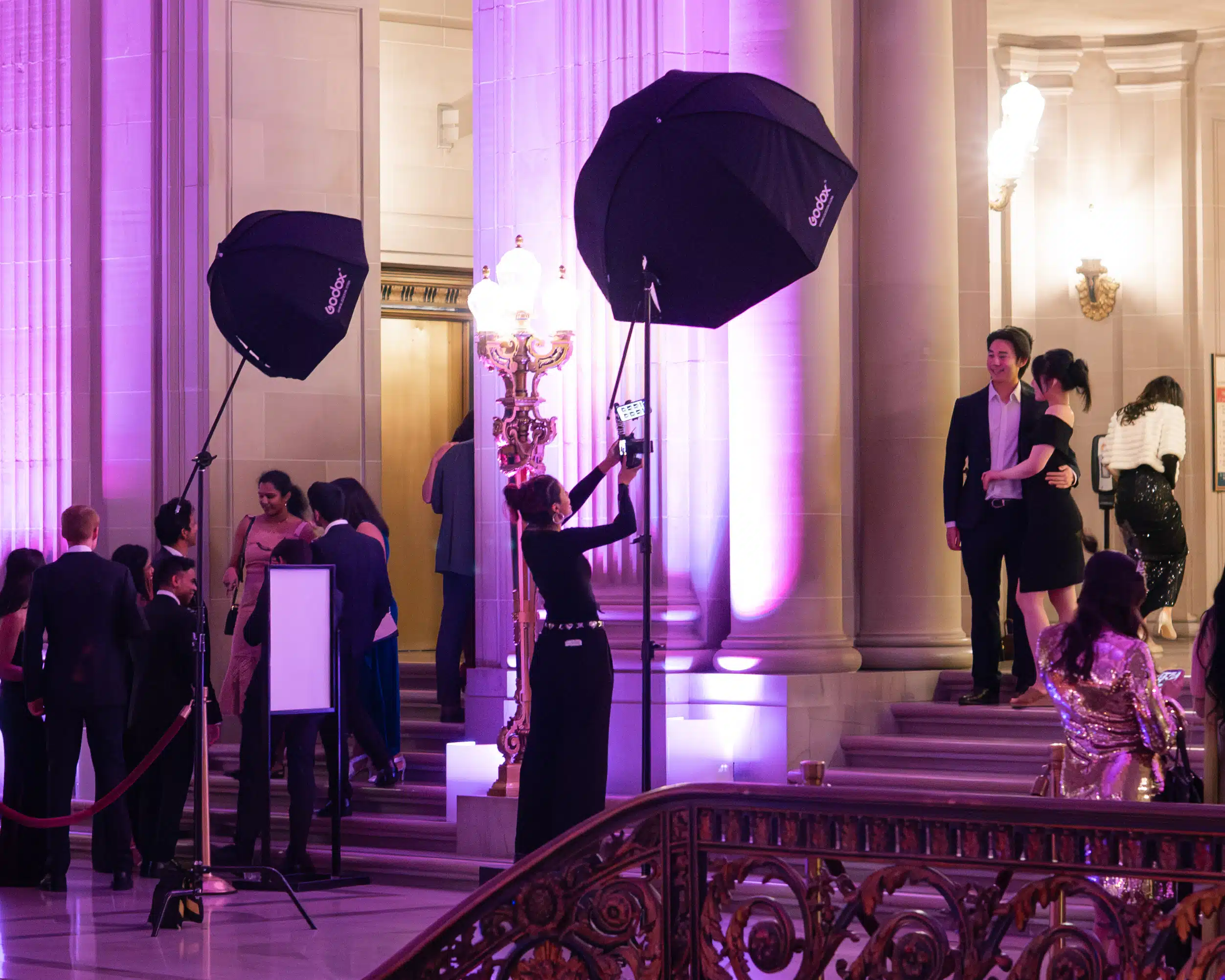 Event guests posing for portraits in a luxury venue, featuring professional lighting, elegant decor, and a photographer capturing editorial-style images for upscale events.