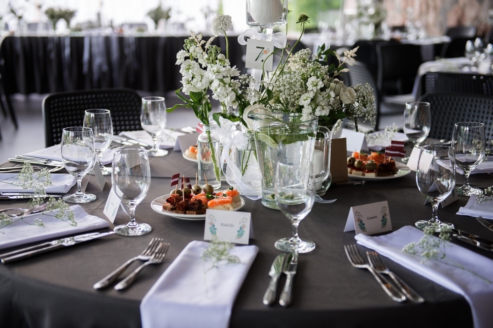 Elegant wedding reception table setting with floral centerpiece, glassware, and assorted appetizers, highlighting event dining and celebration.