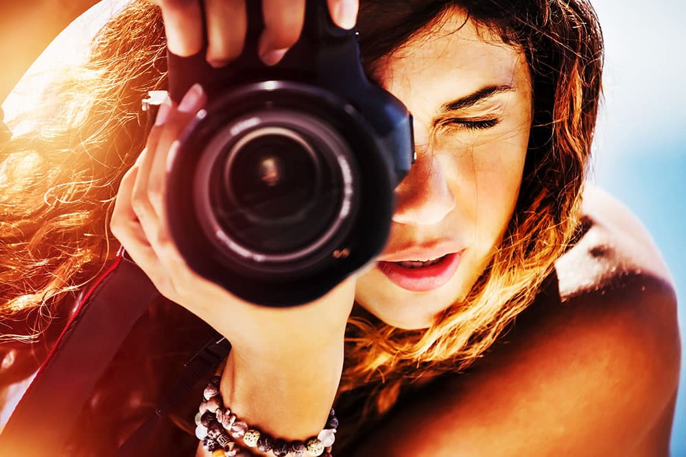 Photographer capturing moments with a camera, emphasizing professional photography for weddings and corporate events.