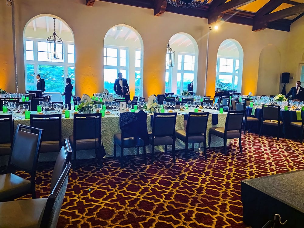 Elegant dining room setup at The Olympic Club in San Francisco, featuring tables adorned with green accents, glassware, and floral arrangements, ideal for corporate events and weddings.