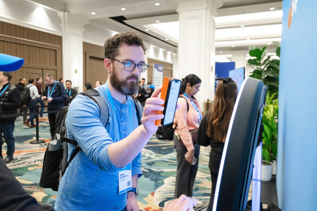Man interacting with a digital trading card activation at a corporate event, showcasing personalized marketing experience by Pop Life Photo.