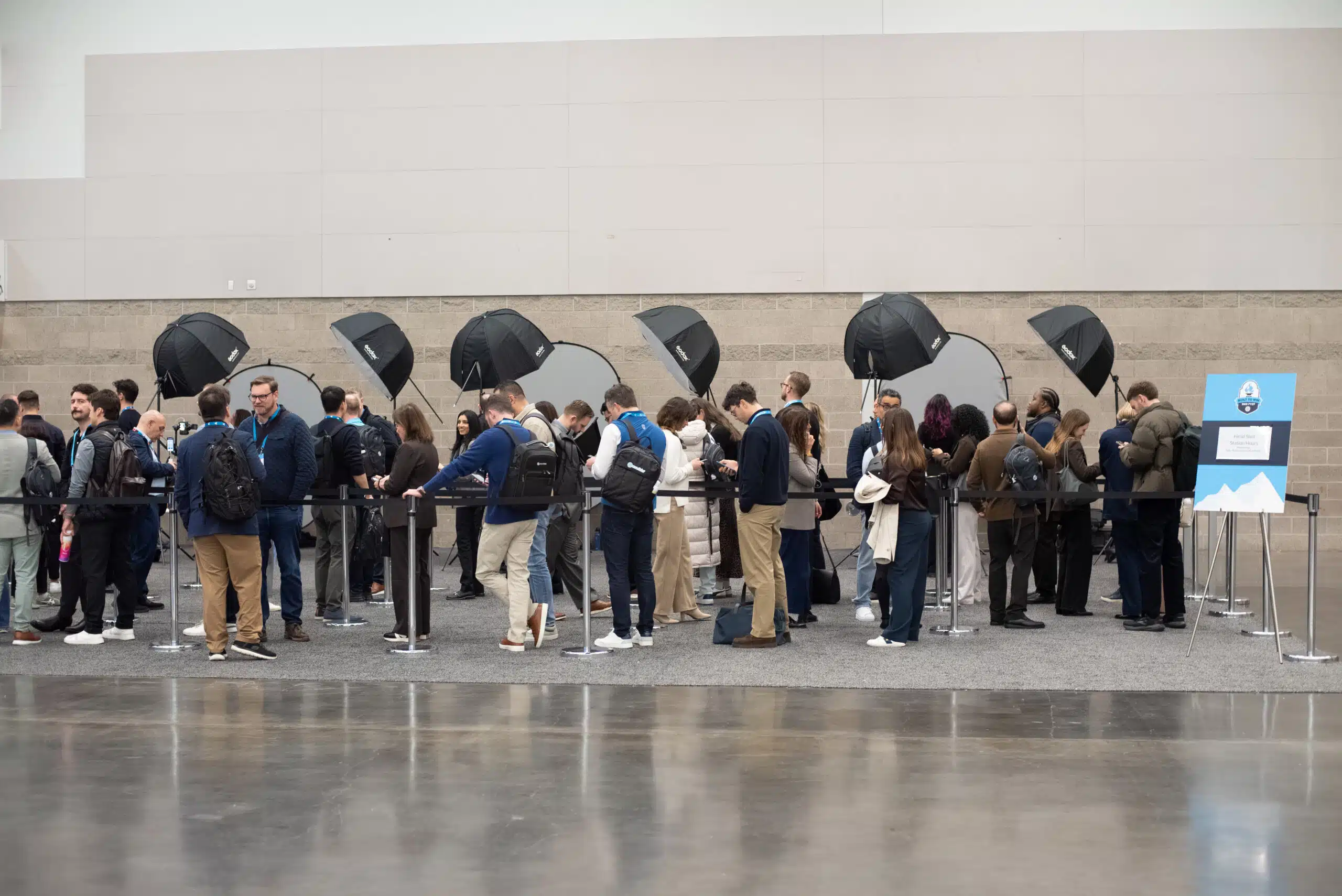 Crowd of attendees at Snowflake AI Innovation Summit waiting in line for professional headshots, with photography equipment including softboxes in the background.
