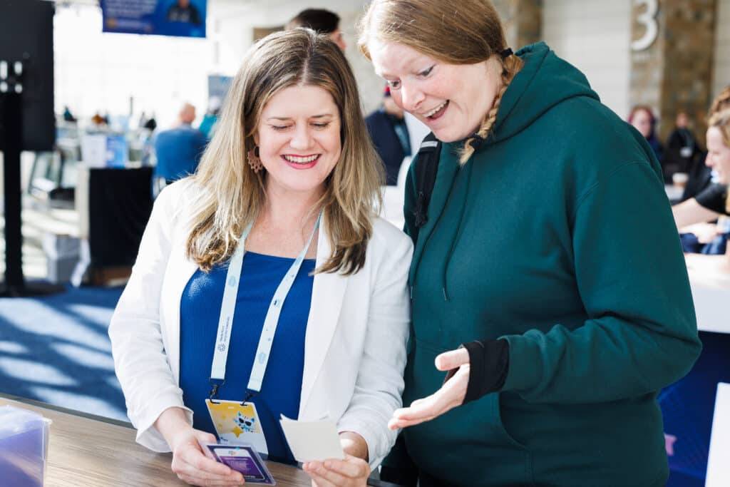 Guests admiring AI Trading Card prints at Pop Life Photo's brand activation at Salesforce TDX 2026